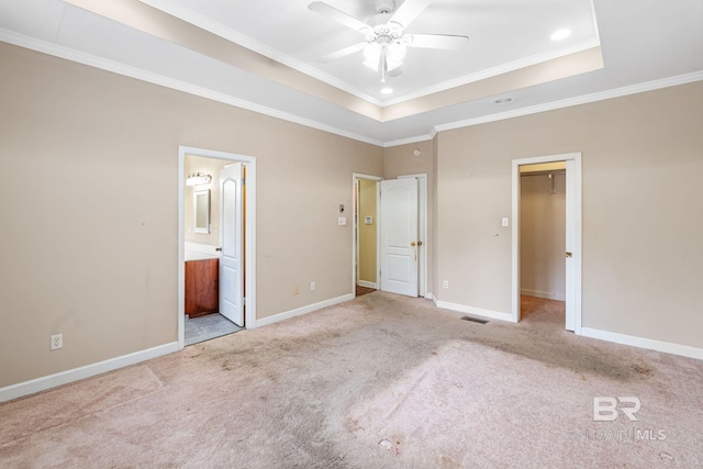 unfurnished bedroom with baseboards, visible vents, a tray ceiling, and carpet flooring