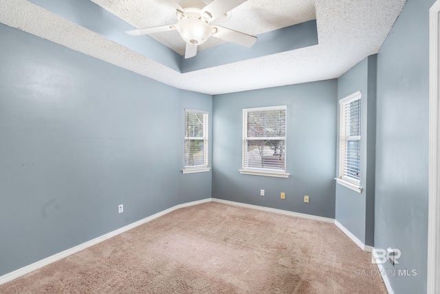 carpeted spare room featuring a ceiling fan, baseboards, and a textured ceiling