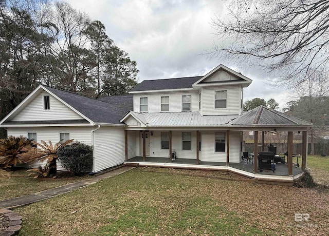 view of front of house featuring metal roof, a front lawn, and fence