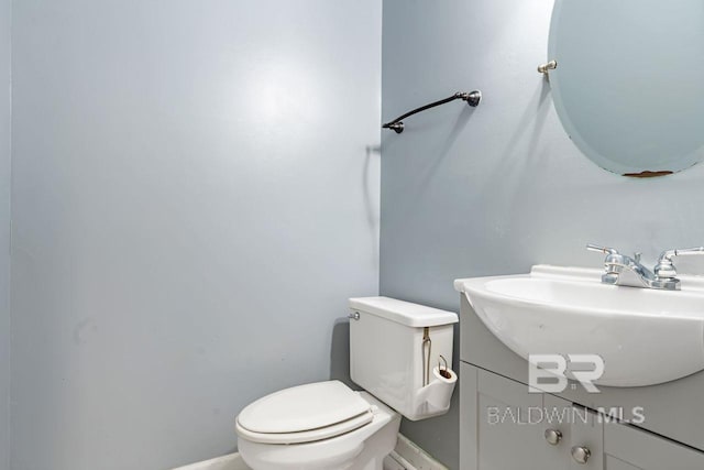 bathroom featuring toilet, baseboards, and vanity