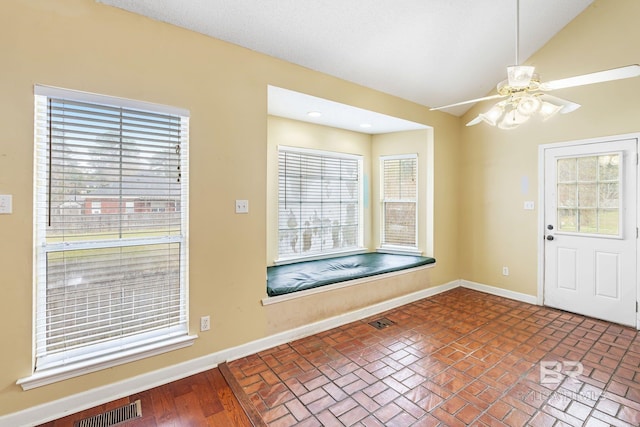 entrance foyer featuring lofted ceiling, visible vents, and baseboards