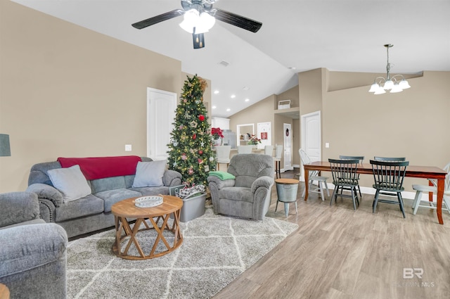 living room with ceiling fan with notable chandelier, light wood-type flooring, and high vaulted ceiling