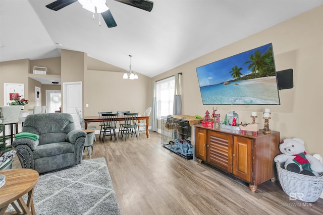 living room featuring ceiling fan with notable chandelier, lofted ceiling, and light hardwood / wood-style flooring