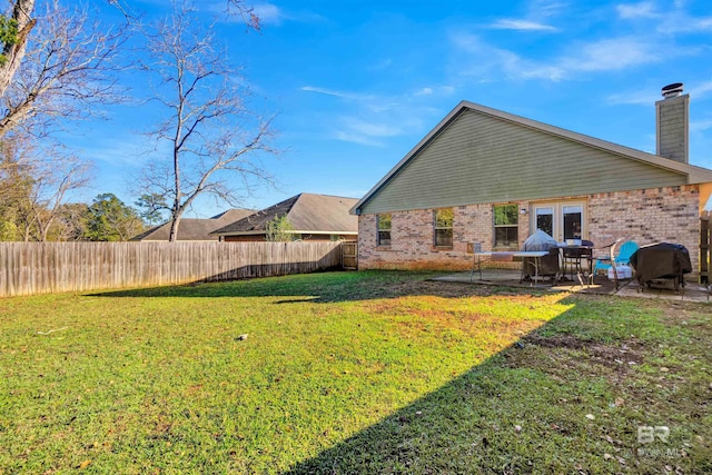 view of yard with french doors and a patio