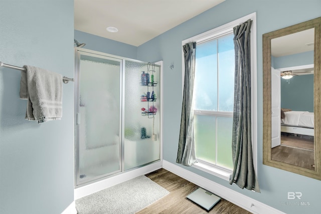 bathroom with ceiling fan, wood-type flooring, and a shower with shower door