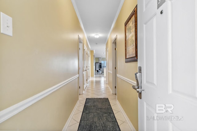 hall with ornamental molding and light tile patterned flooring