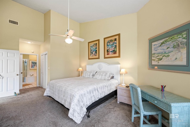 bedroom with ensuite bath, ceiling fan, carpet flooring, a towering ceiling, and a closet