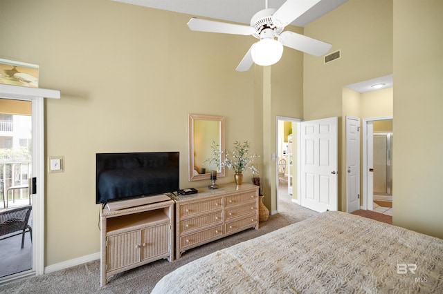 carpeted bedroom featuring a high ceiling, ceiling fan, and ensuite bath