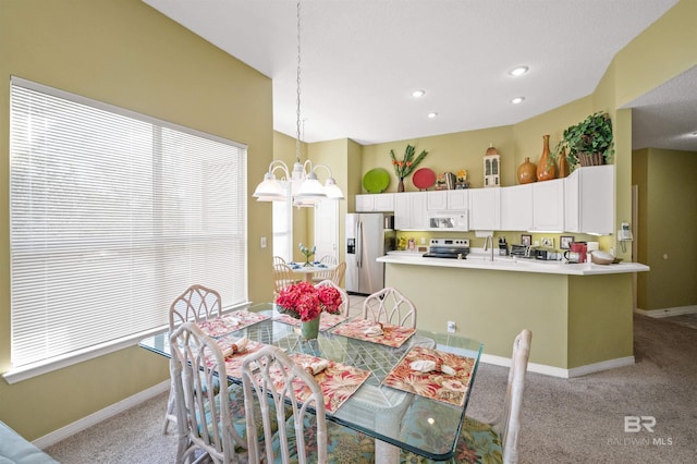 carpeted dining space featuring a notable chandelier