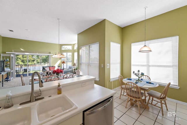 kitchen featuring stainless steel dishwasher, hanging light fixtures, sink, and light tile patterned flooring