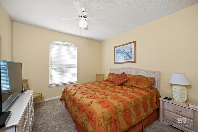 carpeted bedroom with a textured ceiling and ceiling fan