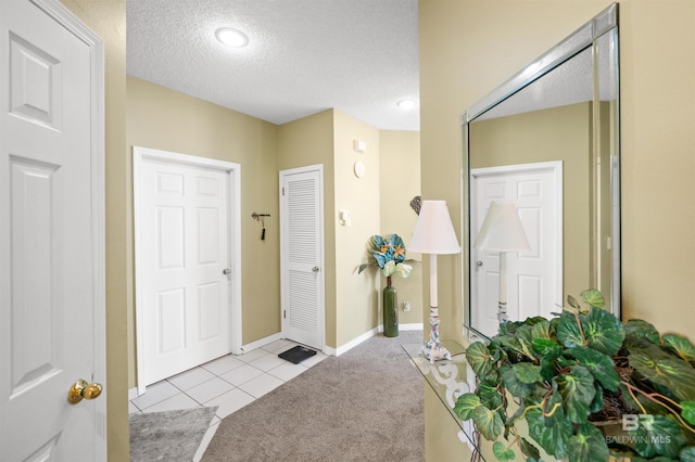 entrance foyer with a textured ceiling and light carpet