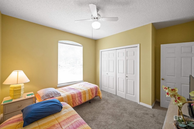 bedroom featuring a closet, a textured ceiling, ceiling fan, and carpet floors