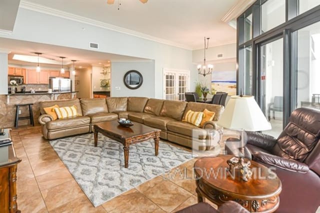 tiled living room with crown molding, a healthy amount of sunlight, and ceiling fan with notable chandelier