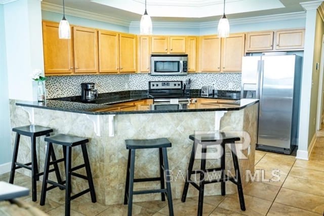 kitchen featuring pendant lighting, a kitchen bar, and appliances with stainless steel finishes