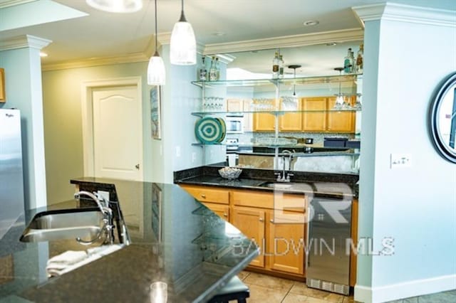 kitchen with ornamental molding, appliances with stainless steel finishes, decorative light fixtures, and sink