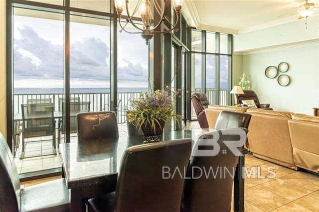 dining space with tile patterned floors, a water view, ornamental molding, a notable chandelier, and a wall of windows