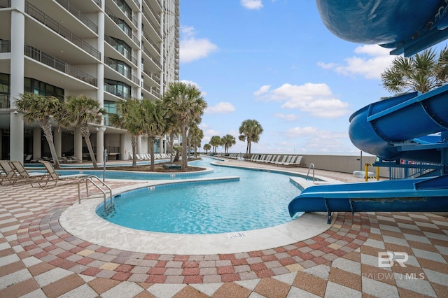 view of pool with a patio and a water slide