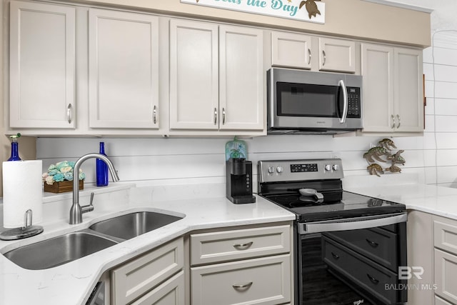 kitchen featuring sink, stainless steel appliances, tasteful backsplash, and light stone countertops