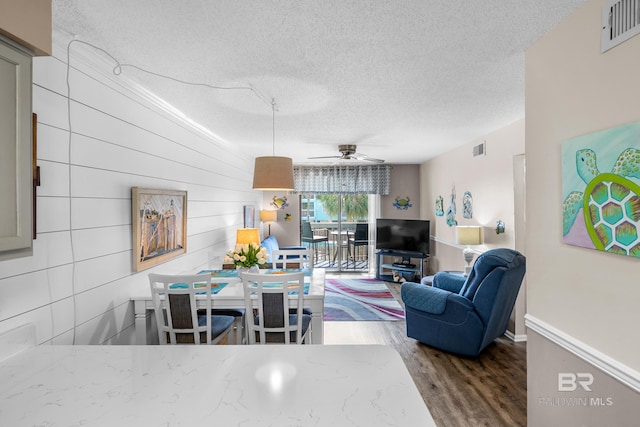 living room featuring hardwood / wood-style floors, a textured ceiling, and ceiling fan