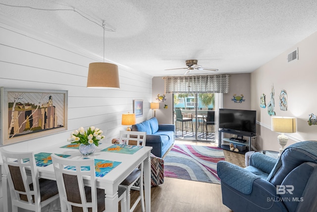 living room featuring hardwood / wood-style floors, a textured ceiling, and ceiling fan