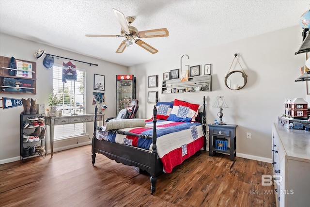 bedroom with ceiling fan, dark hardwood / wood-style flooring, a textured ceiling, and multiple windows