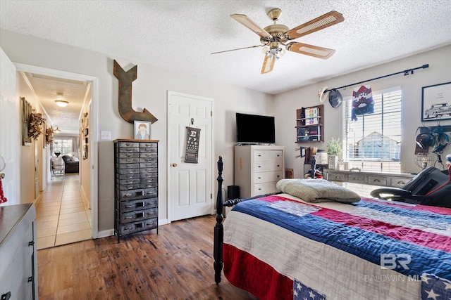 bedroom featuring ceiling fan, a textured ceiling, and hardwood / wood-style flooring