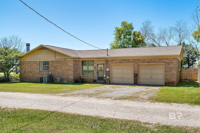 single story home featuring a front yard, central AC, and a garage