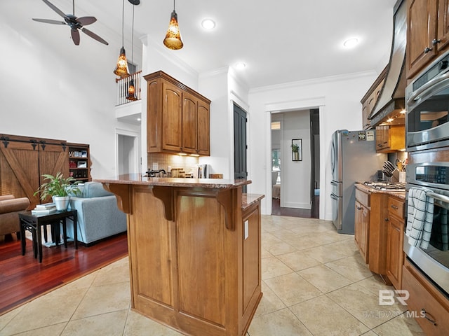 kitchen featuring crown molding, light hardwood / wood-style floors, decorative backsplash, decorative light fixtures, and stone counters