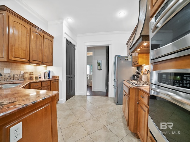 kitchen featuring backsplash, light hardwood / wood-style floors, light stone countertops, stainless steel oven, and custom exhaust hood