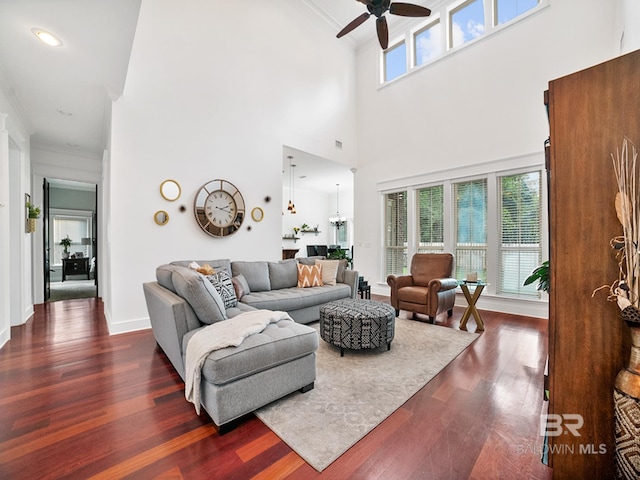 living room featuring dark hardwood / wood-style flooring, ornamental molding, and ceiling fan