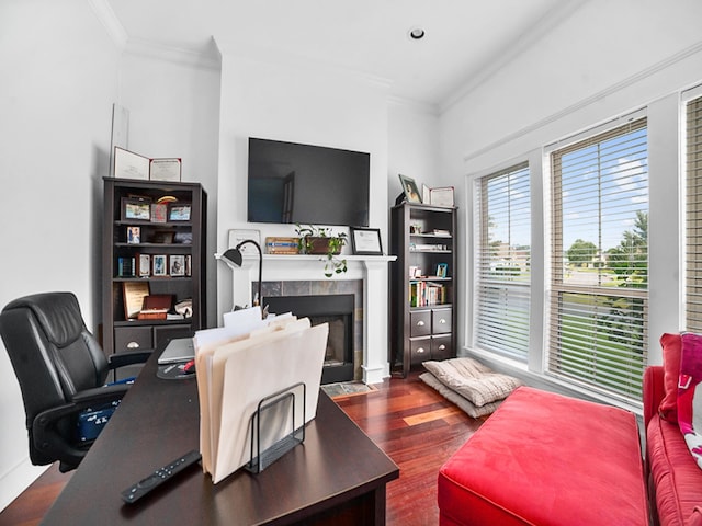 office space with ornamental molding, dark hardwood / wood-style floors, and a tiled fireplace