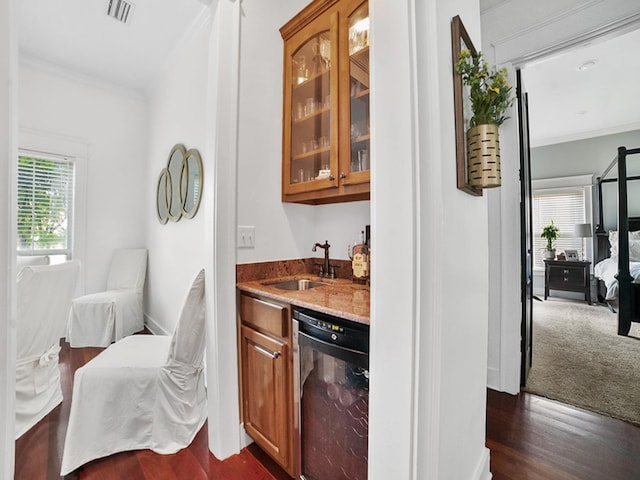 bar with sink, dark carpet, crown molding, stone countertops, and dishwasher