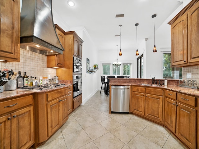 kitchen featuring sink, custom exhaust hood, a chandelier, hanging light fixtures, and appliances with stainless steel finishes