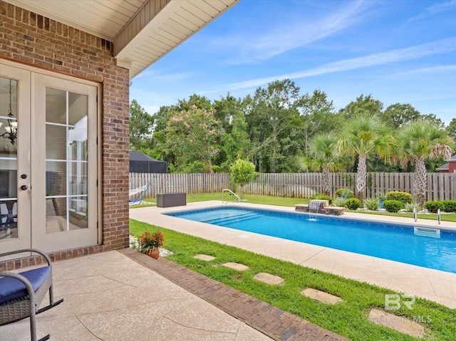 view of swimming pool with french doors, pool water feature, and a patio area