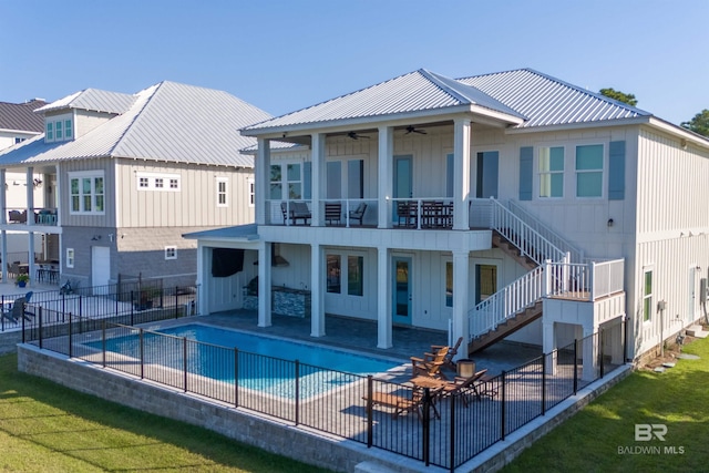 back of house featuring a yard, a patio area, a fenced in pool, and ceiling fan