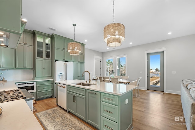 kitchen featuring sink, green cabinetry, and pendant lighting