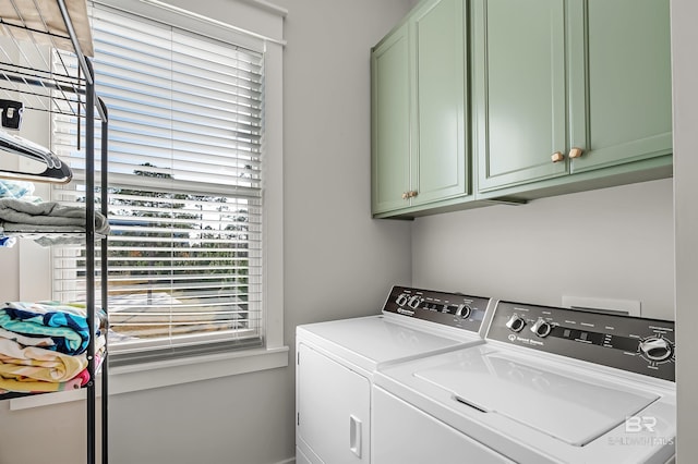 laundry area with washer and dryer and cabinets