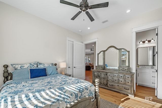 bedroom with light hardwood / wood-style floors, sink, connected bathroom, and ceiling fan