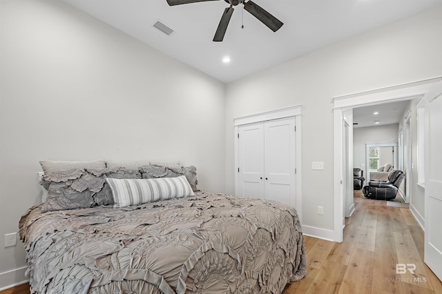 bedroom with a closet, light wood-type flooring, and ceiling fan