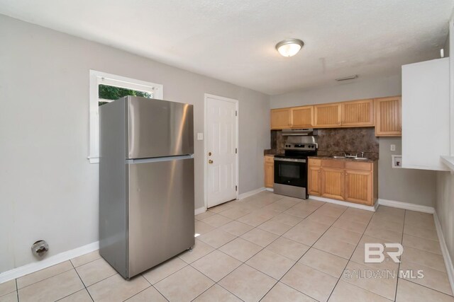 6451 S Barker Dr, Mobile, AL 36608 - kitchen with appliances with stainless steel finishes, light tile patterned floors, a sink, tasteful backsplash, and baseboards