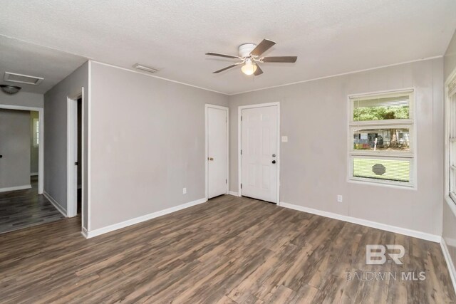 6451 S Barker Dr, Mobile, AL 36608 - empty room featuring wood finished floors, baseboards, ceiling fan, attic access, and a textured ceiling