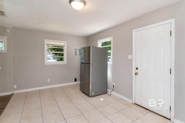 6451 S Barker Dr, Mobile, AL 36608 - kitchen featuring freestanding refrigerator, light tile patterned flooring, and baseboards