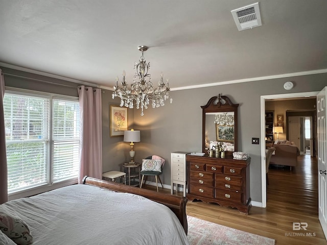 bedroom with a chandelier, dark hardwood / wood-style floors, and ornamental molding