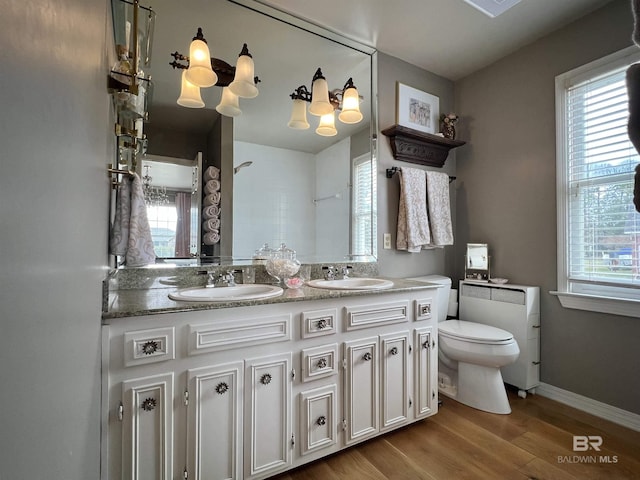 bathroom featuring hardwood / wood-style floors, vanity, a healthy amount of sunlight, and toilet