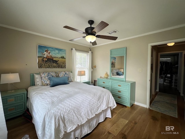 bedroom featuring ceiling fan, crown molding, and dark wood-type flooring