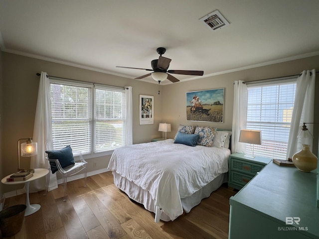 bedroom featuring ceiling fan, hardwood / wood-style floors, and crown molding