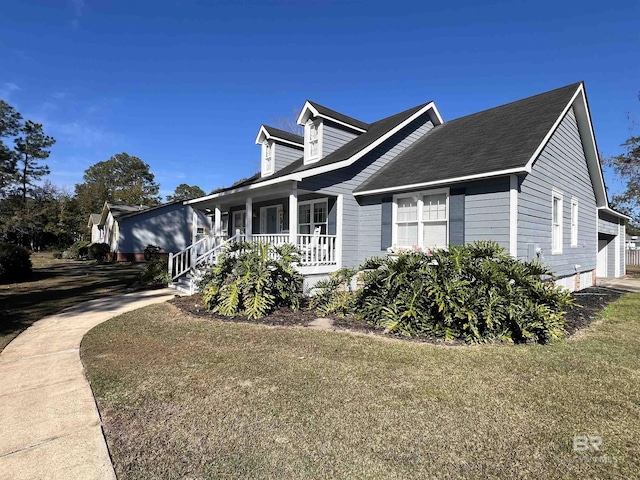 view of side of home featuring covered porch, a yard, and a garage