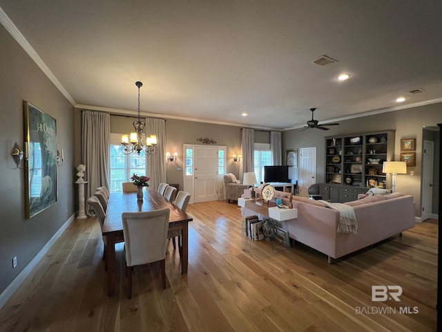 dining area featuring hardwood / wood-style flooring, ceiling fan with notable chandelier, and ornamental molding