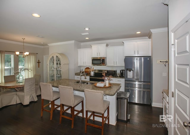 kitchen with dark wood-style flooring, a breakfast bar, white cabinets, a sink, and stainless steel appliances